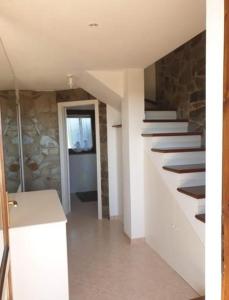 a room with stairs and a stone wall at La Pelosa House 2 in Stintino