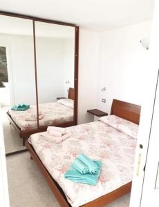 a bedroom with two beds and a mirror at La Pelosa House 2 in Stintino