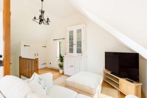 Long MarstonSicca Lodge的配有白色家具和平板电视的客厅