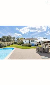 a home with a swimming pool and a house at Maison Pierre 3 bedroom house with swimming pool in Léon