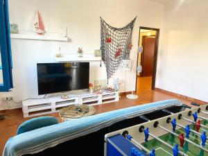 a living room with a tv and a table at Pearl of the sea in Arenella