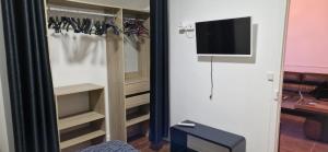 a room with a closet with a tv on the wall at Chez Nathan appartement 2 chambres in Auxerre