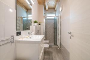 Carate UrioにあるAppartamento con vista Lago di Como e Parcheggio inclusoの洗面台とトイレを備えた白いバスルーム +21枚の写真