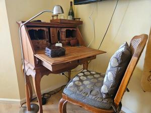 an old desk with a lamp and a chair at La Terre d'Or in Beaune