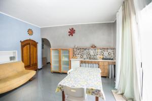 eine Küche mit einem Tisch und einem Tisch und einer Theke in der Unterkunft CASA di PIETRO sulla BAIA in Leporano Marina