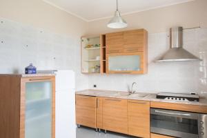 eine Küche mit Holzschränken und einem Herd in der Unterkunft CASA di PIETRO sulla BAIA in Leporano Marina
