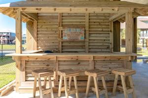 a wooden bar with stools around it at Nauti By Nature home in Crystal Beach