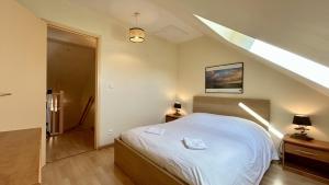 - une chambre mansardée avec un lit blanc dans l'établissement Tribord, charmante maison en duplex au cœur du Crotoy – Idéale pour un séjour en Baie de Somme, au Crotoy