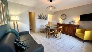 un salon avec un canapé et une salle à manger dans l'établissement Tribord, charmante maison en duplex au cœur du Crotoy – Idéale pour un séjour en Baie de Somme, au Crotoy