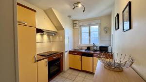 d'une cuisine avec des placards jaunes, un évier et une fenêtre. dans l'établissement Tribord, charmante maison en duplex au cœur du Crotoy – Idéale pour un séjour en Baie de Somme, au Crotoy 1 autre photo