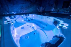 a jacuzzi tub with blue lights in a room at Suite & Spa Le Clandestin ARRAS in Arras