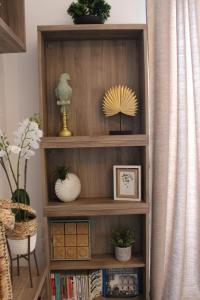 a book shelf with various items on it at Playa Serena - Meublé de tourisme 3 étoiles - Accès Plage & Parking Privé in Carnon-Plage
