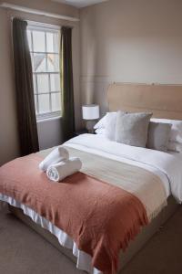 a bedroom with a large bed with towels on it at #3 - King Room at The Raven Aparthotel by PureStay in Much Wenlock