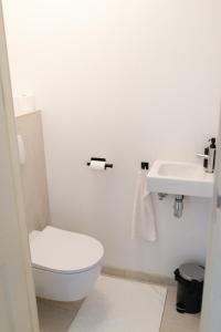 Un baño blanco con inodoro y lavabo. en Canal View Apartment, en Ámsterdam 15 fotos más