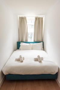 Una cama en una habitación con dos zapatillas. en Canal View Apartment, en Ámsterdam