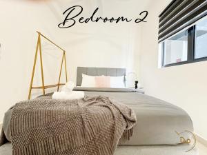 シャー・アラムにあるSpacios Cozy Homestay Huni at Setia Alam KL 3 rooms 2 bathroomの毛布がかけられたベッドのある寝室