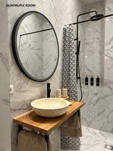 a bathroom with a sink and a large mirror at El Sol Zandvoort in Zandvoort