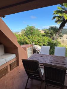 a wooden table and chairs on a patio with a view at Domus Strazza Porto Quadro in Santa Teresa Gallura