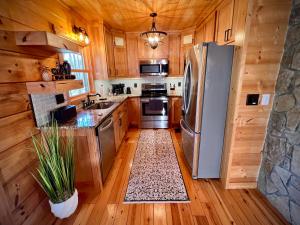 エリジェイにあるEllijay Cabin - Cozy Fall Hideaway & Hot Tubのキッチン(ステンレス製の電化製品、木製キャビネット付)