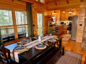 a kitchen and dining room with a table in a cabin at Mountain Hideaway - Hot Tub, Fire Pit, Close to Town in Ellijay