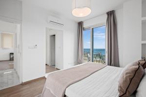 a bedroom with a bed and a view of the ocean at Cavo Aspro Luxury 3-bed Villa by Nomads in Pissouri +20 photos