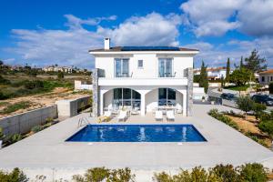 a villa with a swimming pool and a house at Cavo Aspro Luxury 3-bed Villa by Nomads in Pissouri