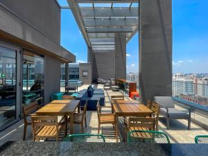 Nine: Conforto e Sofisticação no Jardim Paulista في ساو باولو: شرفة على طاولات وكراسي خشبية في مبنى