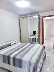 a bedroom with a bed and a large mirror at Casa de praia Imbassaí in Mata de Sao Joao