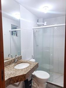 a bathroom with a toilet and a sink and a shower at Casa de praia Imbassaí in Mata de Sao Joao