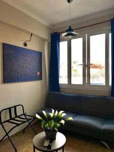 uma sala de estar com um sofá azul e uma mesa em Monastiraki 510 SuperHost Hub em Atenas