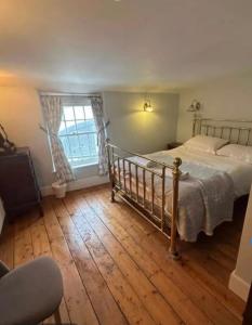 a bedroom with a bed and a wooden floor at Little Monmouth 4 bedroom cottage, Old town Lyme Regis, dog friendly and parking in Lyme Regis