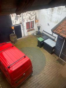 a red car parked in a yard with a picnic table at Althuizenhof - Jelle in Doenrade +19 photos