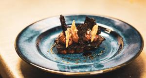a blue plate with a dessert on a table at Whatley Manor in Malmesbury