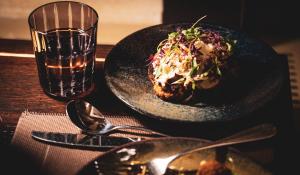 a table with two plates of food and a glass at Whatley Manor in Malmesbury