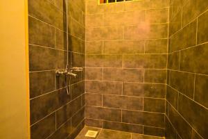 a bathroom with a shower with a tiled wall at Rafiki Retreat in Arusha +61 photos