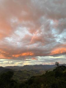 a cloudy sky with mountains in the distance at Sitio São Sebastião in São Bento do Sapucaí +1 photo