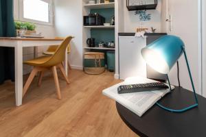 Eine Lampe stand auf einem Tisch, daneben ein Buch und eine Tastatur. in der Unterkunft Le tiny in Colmar + 9 Fotos