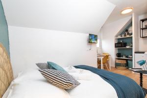 ein Schlafzimmer mit einem Bett und einem Fernseher an der Wand in der Unterkunft Le tiny in Colmar