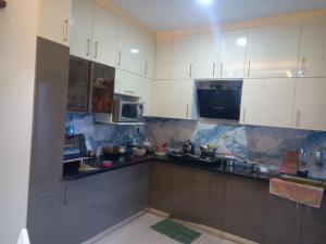 a kitchen with white cabinets and a counter top at Stay comfort at City Heart 2Bhk AC ,WIFI & Much more in Indore