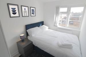 a bedroom with a white bed and a window at 3Bed Central Flat - free parking in Leamington Spa