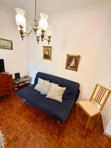 a living room with a blue couch and a chair at Casa da Mariazinha in Costa da Caparica