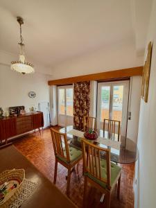 a dining room with a table and chairs and a kitchen at Casa da Mariazinha in Costa da Caparica