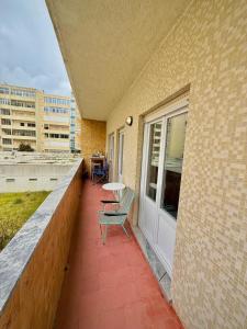 a balcony with a table and a chair on a building at Casa da Mariazinha in Costa da Caparica