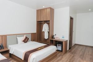 um quarto com uma grande cama branca e pisos em madeira em Long Hải Hotel em Móng Cái mais 4 fotografias