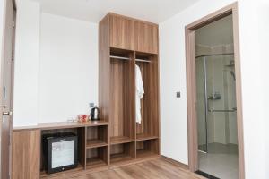 uma casa de banho com um armário de madeira e uma cabina de duche em vidro. em Long Hải Hotel em Móng Cái