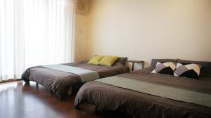 Dos camas una al lado de la otra en un dormitorio. en Perfect for families Spacious 4bedrooms up to 16guests Washer-dryer Car Free Parking ファミリーに最適 4LDK 最大16名 洗濯乾燥機 駐車場無料, en Osaka