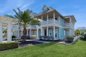 a large white house with a palm tree at Golf Course Living at Palmilla Beach in Port Aransas