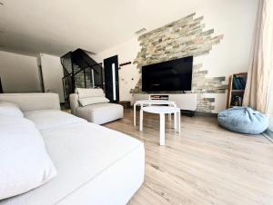 a living room with two beds and a flat screen tv at Villa plein Sud, clim et piscine, 6 à 8 personnes in Boisseron
