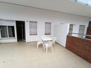 a white table and chairs on a patio at APCOSTAS Els Pins Lotus in Blanes +111 photos