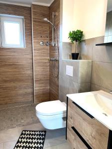a bathroom with a toilet and a shower and a sink at Balance Apartments by M&A Train Station Business in Witzenhausen +2 photos